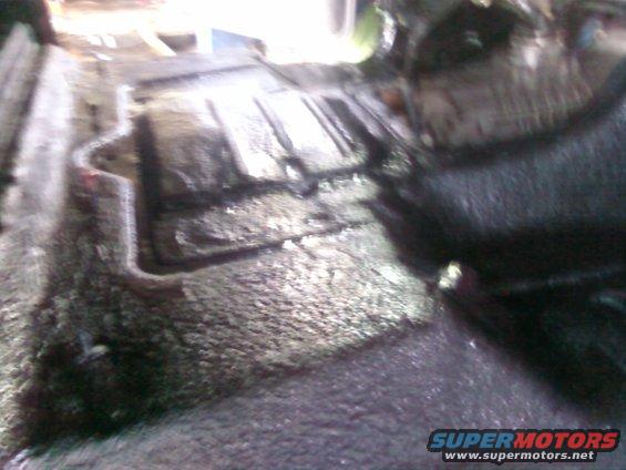 Underbody view of a vehicle with visible rust and grime
