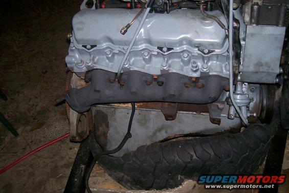 Engine block with exhaust manifold and fuel pump visible