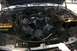1992 Ford C-350 (Centurion Conversions) - The engine bay of a vehicle is shown with the hood open, revealing the engine components and two batteries.