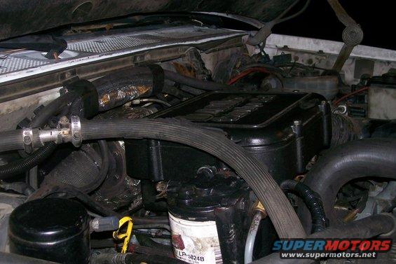 Engine bay with black engine cover and hoses