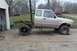 1997 Ford Ranger - A tan 1997 Ford Ranger chassis sits on a concrete driveway next to a garage, with another red truck visible in the background.