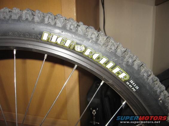 Close-up of a bicycle tire with 'HIGH ROLLER' text and '26 x 2.35' size marking