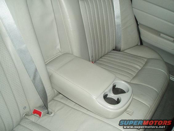 Light tan leather rear seat with armrest and cup holders. 2003 Ford Crown Victoria