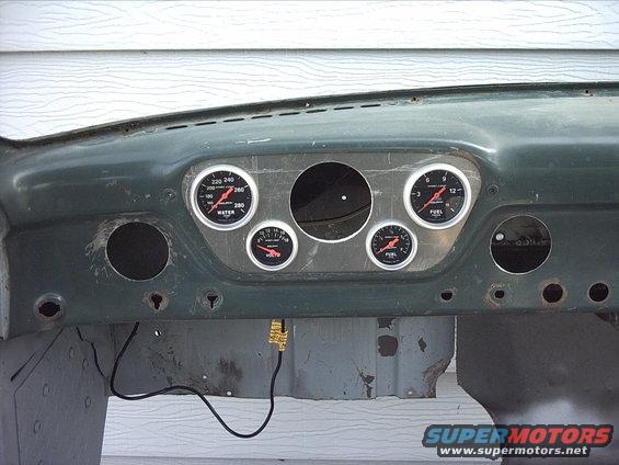 5-17-09:      Today I  did some more work on the instrument panel. I marked out where I wanted the gauges and drilled some pilot holes then used my hole saws to make 5 holes. I had an issue with the hole saws wobbling. It made just enough of a problem to throw the alignment of some of the gauges off. But it's good enough for me. If I get bored someday after the truck is on the road I'll make a new panel.

Then I installed all the gauges I've got so far to see how they fit. I used my fuel pressure gauge in place of the oil pressure gauge ( which I don't have yet ) . I think it'll look pretty good. I'm going to paint the dash blue to match the body and I think I'm going to paint the gauge panel white.