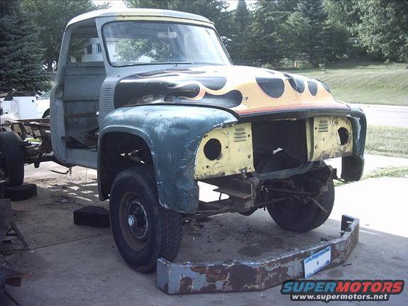3096478_51_full.jpg 8-10-08: Right now the front of the cab and the front clip are sitting a little too high. I 'm going to need to do some cutting/trimming on the inner fender panels and the front frame horns to get it down.

The passenger side fender is pretty messed up. I knew it had a dent but the whole fender is just twisted out of shape. It doesn't fit the cab well, the hood gap is all messed up. I can't bolt the valance to it. And it has some pretty bad rusted areas. I'm thinking about trying to find a better F600 fender and just replace it.

I was going to paint the truck a bright Ford blue. But the more I look at it the more it's screaming for a black paint job. It seems like the more parts I put on it the more it's developing a bad attitude! 