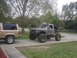1984 Ford Bronco II - A heavily modified truck with oversized tires and a roll cage sits on a driveway next to a standard SUV.