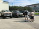 1993 Ford Bronco - Several Ford Broncos are gathered in a parking lot with people standing around them.