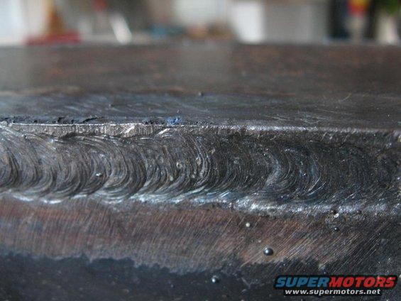 Close-up of a metal seam with visible weld beads and some small bubbles