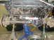 1984 Ford Bronco II - The vehicle's undercarriage is supported by jack stands, revealing its suspension and steering system components.