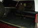1986 Ford Bronco - The cargo area of an SUV shows a spare tire and two large black tanks mounted on the floor.
