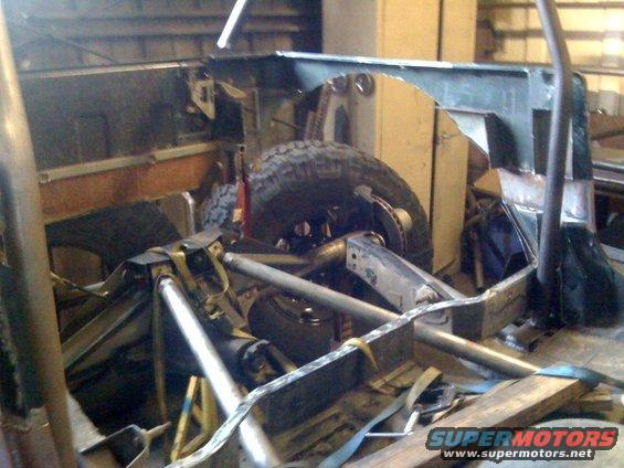 Jeep YJ frame and suspension during a build, showing roll cage and suspension components