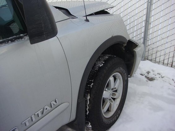 2008 Nissan Titan front fender and wheel in snow, hood is open