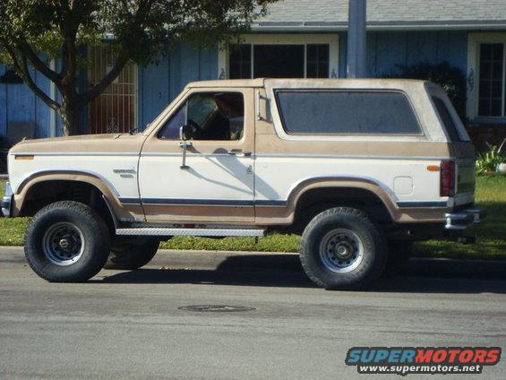 Side view of a two-tone brown and white Ford Bronco parked on a street