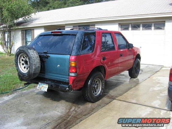Red and teal SUV, rear view, with spare tire on back. Matches 1993 Isuzu Rodeo