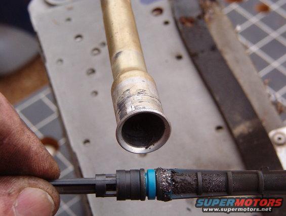 10screen.jpg This orifice tube is blue (with black residue on most of it), indicating it's for R-12.  Note the fine metal shavings on the filter screen, indicating 1) that the compressor has failed, & 2) that there are more shavings between the compressor & evaporator: in the high-side line, in the condenser, & in the condenser-to-evaporator line.  The lines must be flushed to remove these filings so that the new compressor isn't damaged.  But Ford says flushing the condenser is INeffective at removing the filings from it, so a new condenser is required.

[url=https://www.supermotors.net/registry/media/952405][img]https://www.supermotors.net/getfile/952405/thumbnail/orifice.jpg[/img][/url] . [url=https://www.supermotors.net/registry/media/71660][img]https://www.supermotors.net/getfile/71660/thumbnail/orifice-tube.jpg[/img][/url]

The reason this compressor failed was probably because of overcharging.  I removed 3 lbs 4 oz from this system, which is 8 oz (1/2 lb) too much.  This probably resulted in liquid refrigerant entering the compressor, causing it to hydraulic, which would explain the shavings.