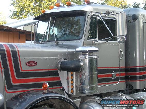 1984 Peterbilt 359 truck, silver with red and black stripes, showing the driver's side front quarter