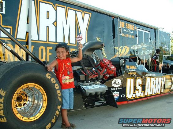 Dragster with U.S. Army livery and a child holding an American flag
