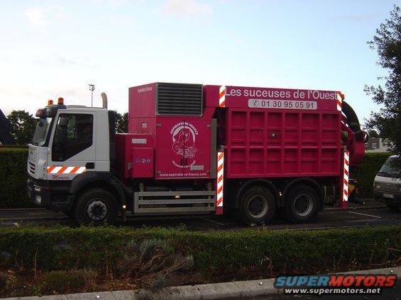 Red and white truck with vacuum equipment, side view. Text reads 'Les suceuses de l'Ouest'