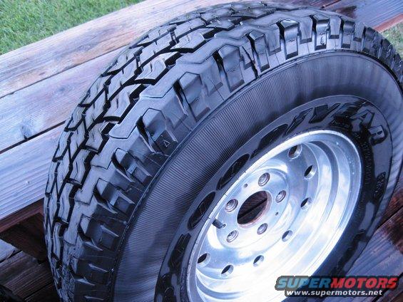 Close-up of a tire with aggressive tread pattern on a polished aluminum rim