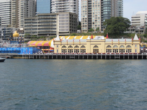 Waterfront buildings with arched windows and colorful awnings, seen from the water