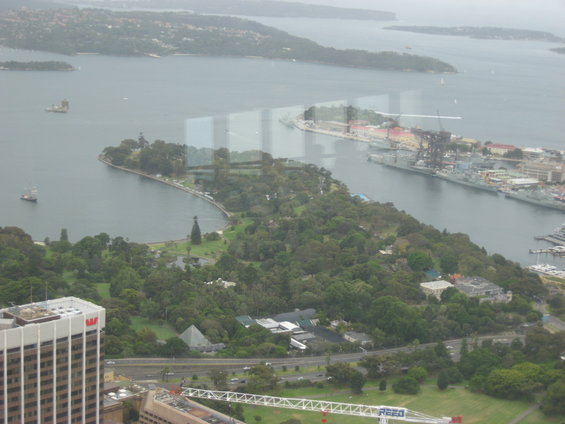 Aerial view of Sydney Harbour, showing a park, buildings, and ships in the water