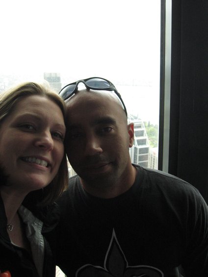 Couple taking a selfie indoors with a city view out the window