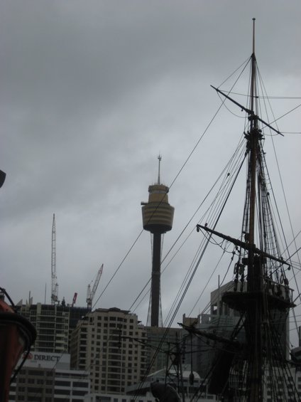 Sydney Tower Eye and ship mast against cloudy sky