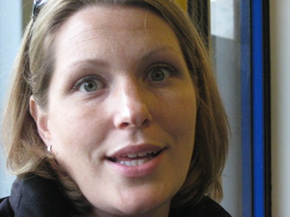 Close-up of a woman's face with light brown hair and green eyes