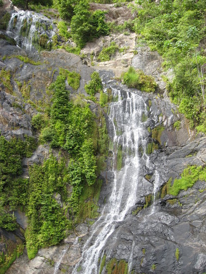 Waterfall cascading down a rocky, vegetated mountainside
