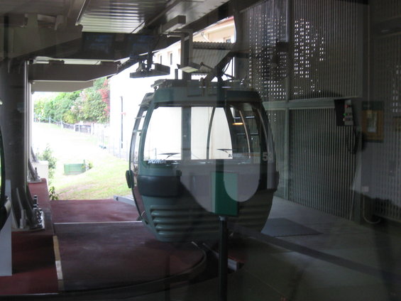 Cable car waiting at station, showing green and white stripes on its side and the number 53