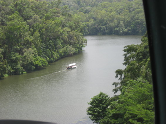 Houseboat on a wide river surrounded by lush green forest