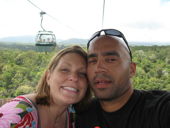 Couple taking a selfie in a cable car with a forest view below