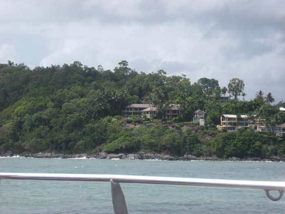 Houses on a hill above the water, with trees covering the landscape