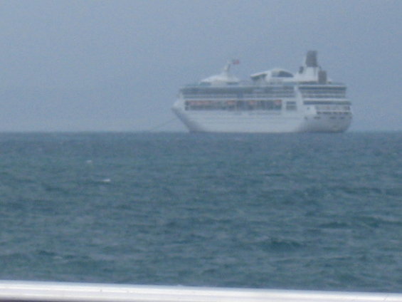 White cruise ship on the ocean under a hazy sky