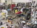 1978 Ford F-250 - A vehicle chassis and engine are being worked on in a cluttered workshop environment, with a large tire and various tools present.