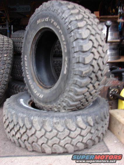 Two BFGoodrich Mud-Terrain T/A tires stacked, one on top of the other. The top tire has visible text