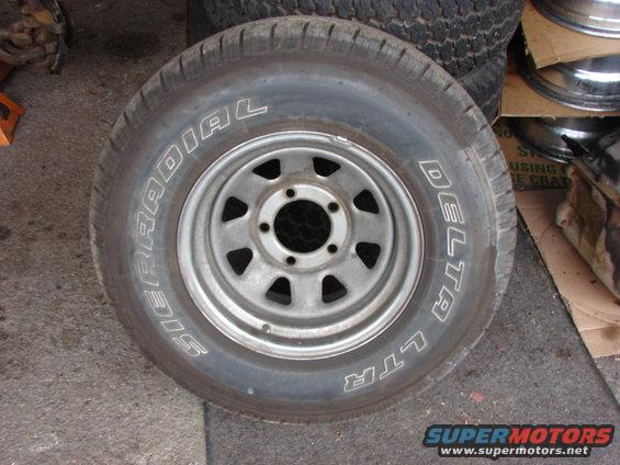 Tire with white lettering 'SIERRA RADIAL' and 'DELTA LTR' on a silver 5-hole rim
