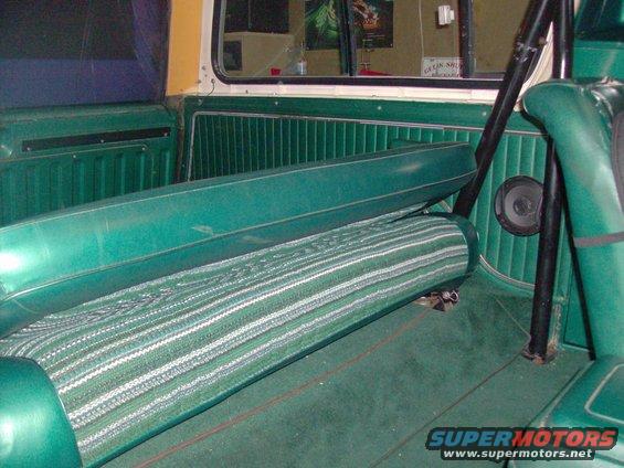 Green striped rear bench seat and interior paneling of a vintage SUV