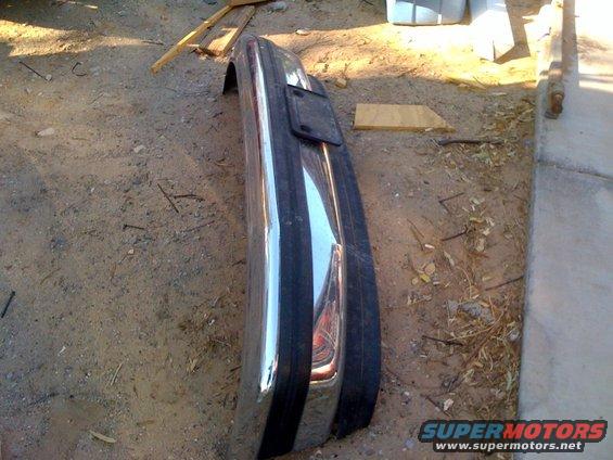 Chrome bumper with license plate bracket lying on the ground