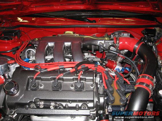 Engine bay with red spark plug wires and silver intake manifold