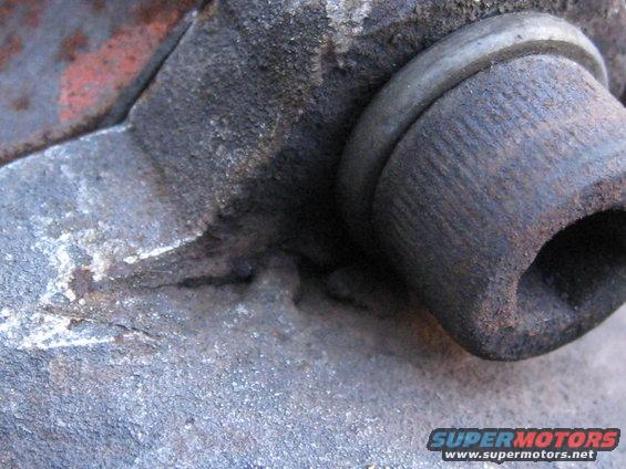 Rusty metal part with hexagonal opening and Supermotors.net watermark