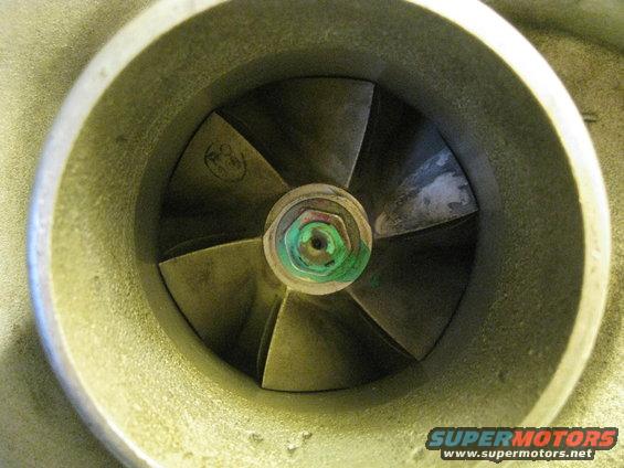 Turbocharger compressor wheel with visible markings and a green-tinted nut