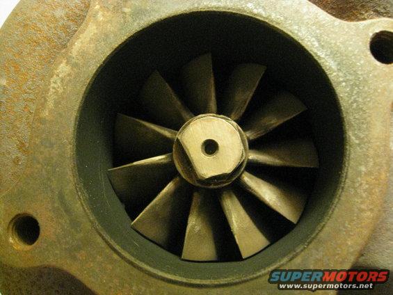 Close-up of a turbocharger compressor wheel with visible blades and a central hub