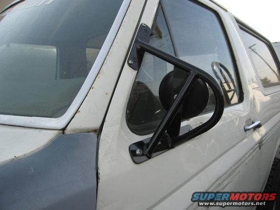White Ford Bronco with aftermarket side mirror and dark fender