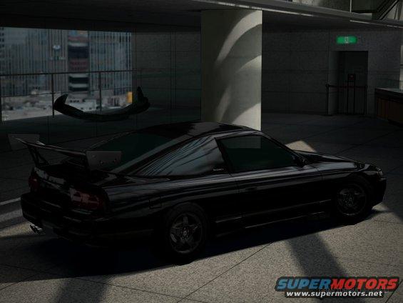 Black sports coupe with a large rear spoiler parked indoors