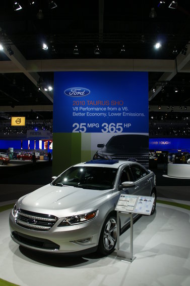 Silver 2010 Ford Taurus SHO on display with specs on a sign