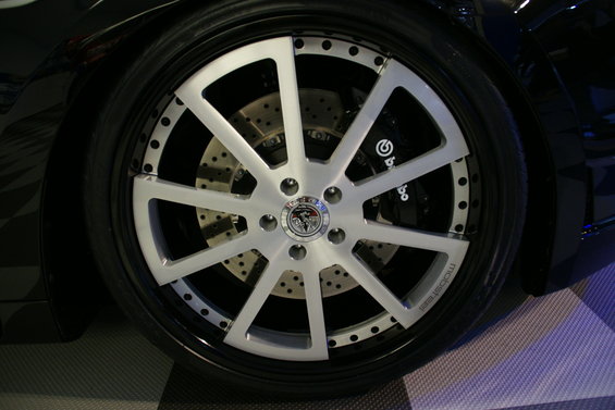 Close-up of a custom silver multi-spoke wheel with drilled rotors and Brembo brake calipers