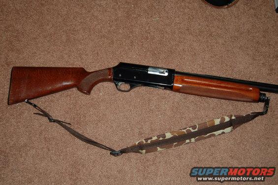 Shotgun with wooden stock and camouflage sling