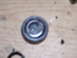 1991 Ford Bronco - A close-up of a single metal component, possibly a cap or cover, resting on a wooden surface.