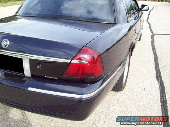 Dark blue sedan rear quarter view, showing tinted tail lights and chrome trim
